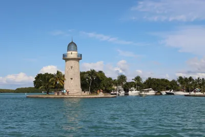 Ornamental stone lighthouse and docked boats at Boca Chita Harbor, serving as the primary landmark for the Boca Chita Key Loop Trail in Biscayne National Park, Florida.