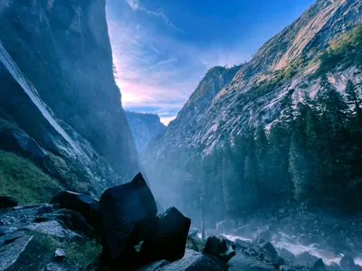 Deep granite canyon filled with mist from the rushing river along the Mist Trail in Yosemite National Park, California.⁠